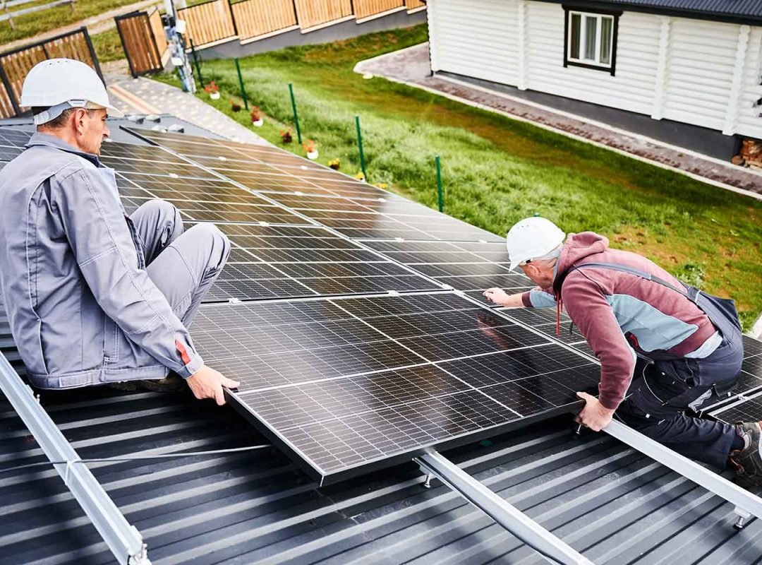 men-workers-installing-solar-panels-on-roof-of-hou-Y7V465M.jpg